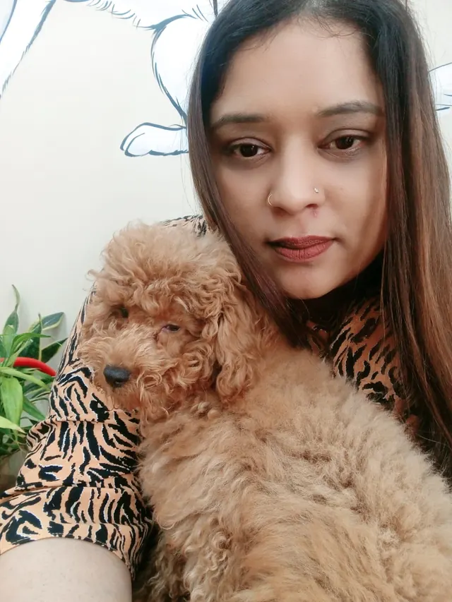 Renjitha holding a small apricot poodle