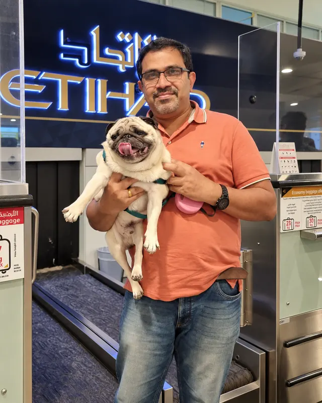 Sujith Gangadharan holding a pug at airport check-in